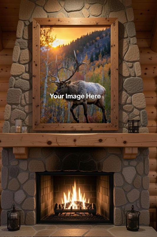 Stone fireplace with wooden mantel and framed picture of a bull elk in a forest.